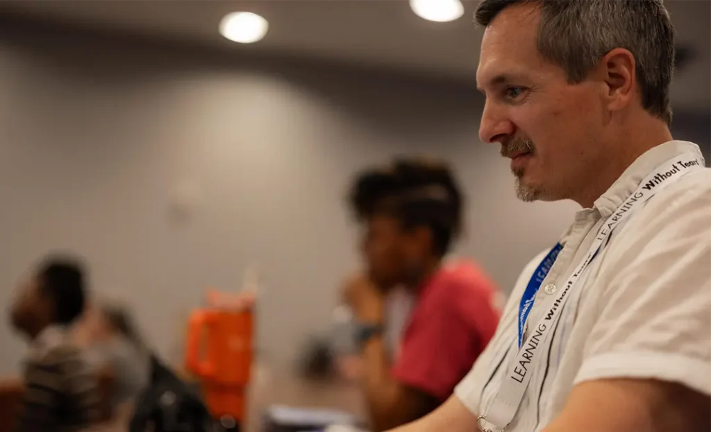 Educator attentively listening during a professional learning session at the Spring CUE Conference, focused on technology integration in education